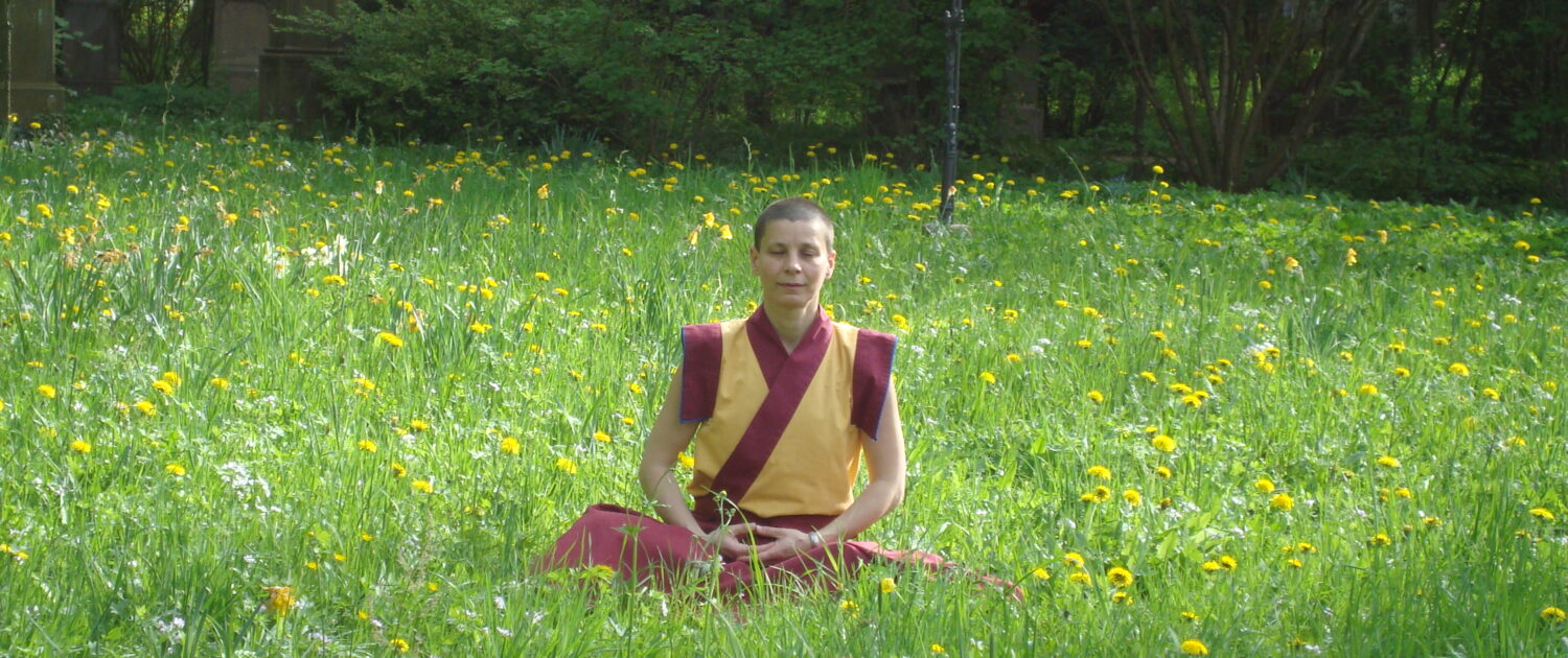 Kelsang Shenyen beim Meditieren auf einer Wiese