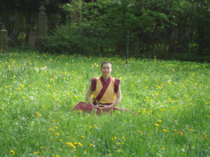 Kelsang Shenyen beim Meditieren auf einer Wiese